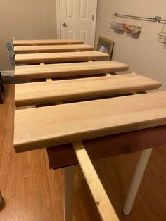 several wooden benches lined up on the floor in a room with wood floors and white walls