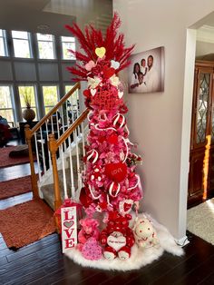 a pink christmas tree decorated with red and white ornaments in the shape of heart shapes