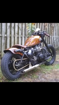 a motorcycle parked in front of a wooden fence