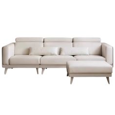 a white couch and ottoman with pillows on it