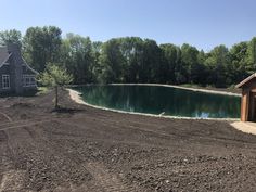 an image of a pond being built on the side of a road with trees in the background