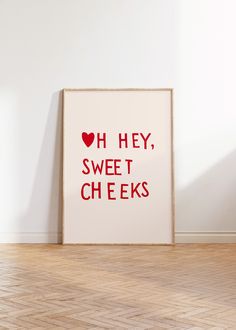 a framed poster with the words oh hey, sweet cheeks on it in front of a white wall