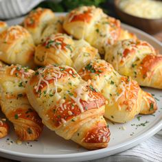 a white plate topped with cheesy pastries covered in cheese