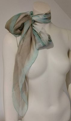 a white mannequin wearing a blue and grey scarf