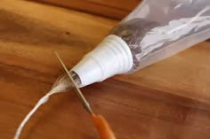 a small bird is sitting in a plastic bag on a table with a pair of scissors