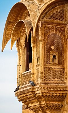 two birds sitting on the ledge of an ornate building