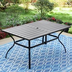 an outdoor table sitting on top of a blue rug