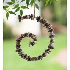 a wind chime hanging from a tree in the shape of a spiral with leaves