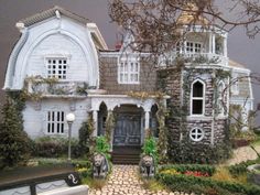 a model house is shown in front of a tree