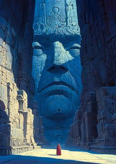 a man standing in front of a giant blue head with egyptian writing on it's face