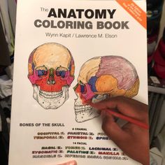 the anatomy coloring book is being held up