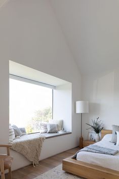 a bedroom with white walls and wooden floors