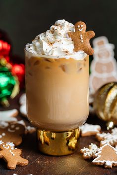 there is a drink with whipped cream and gingerbreads on the table next to it