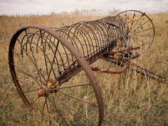 an old rusted metal wheel in a field