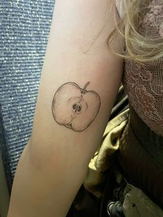 an apple tattoo on the left arm