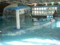 people are playing in the water at an indoor swimming pool