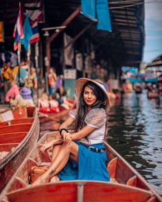 a woman is sitting in a boat on the water