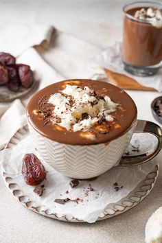 there is a chocolate dessert with whipped cream in the bowl and cherries on the plate