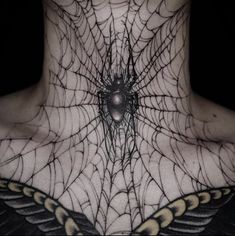 a spider web tattoo on the back of a woman's neck, with wings