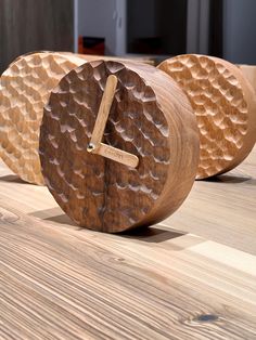 three wooden clocks sitting on top of a table