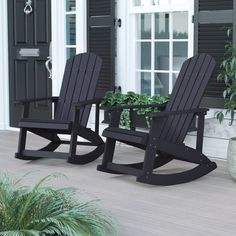 two black rocking chairs sitting on top of a porch