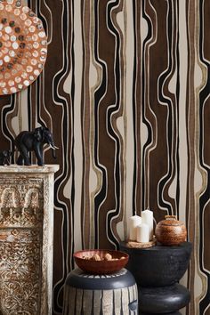 two black and white vases sitting on top of a table next to a wall