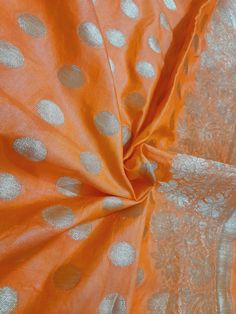 an orange fabric with silver polka dots on it