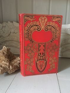 a red and gold book sitting on top of a white table