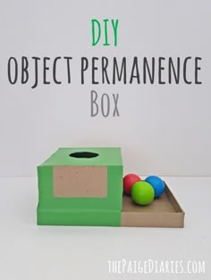 the diy object permanence box is made out of cardboard and plastic balls