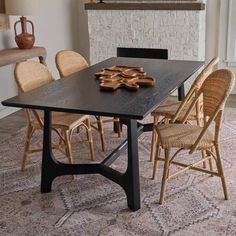 a dining room table with chairs around it and a fireplace in the backround