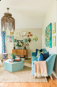 a living room with blue couches and pictures on the wall above them, including a chandelier