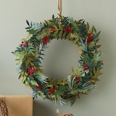 a christmas wreath hanging on the wall next to a present box and tree ornament