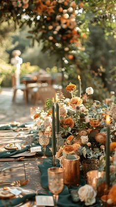 the table is set with candles, plates and napkins for an outdoor dinner party