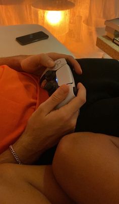 a person sitting on a couch holding a cell phone in their hand and looking at the screen