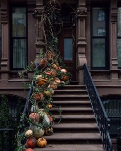 pumpkins and gourds are hanging on the stairs