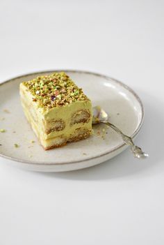 a piece of cake sitting on top of a white plate with a spoon in it