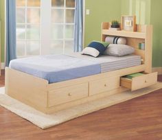 a bed with two drawers underneath it and a blue blanket on the top of it