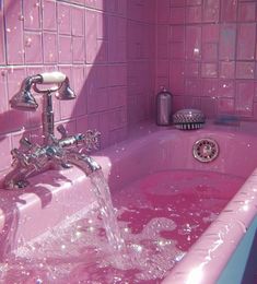 a pink bathtub filled with water next to a faucet