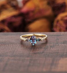 a gold ring with an oval cut blue topazte and three small diamonds