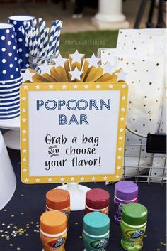 there is a sign that says popcorn bar grab a bag and choose your flavor on the table