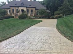 a brick driveway leading to a large house