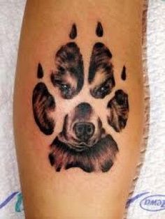 a dog's paw tattoo is shown on the side of a person's leg