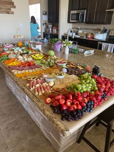 a kitchen island covered in fruit and vegetables