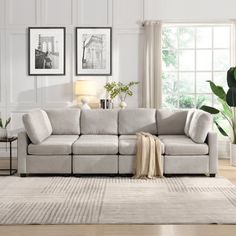 a living room scene with focus on the sectional sofa and large window in the background