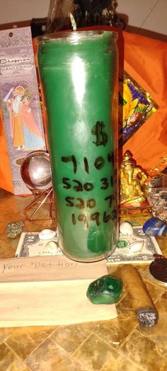 a green cup with writing on it sitting on a table next to some other items