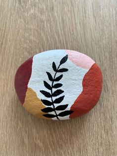 a painted rock sitting on top of a wooden table