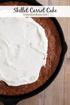 skillet carrot cake with white frosting in a cast iron pan on a wooden table