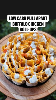 a bowl filled with pasta and sauce on top of a wooden table next to trees