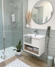 a white sink sitting under a mirror next to a bath tub and shower head mounted on a wall