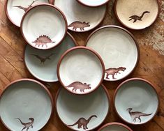 there are many bowls with dinosaurs painted on them